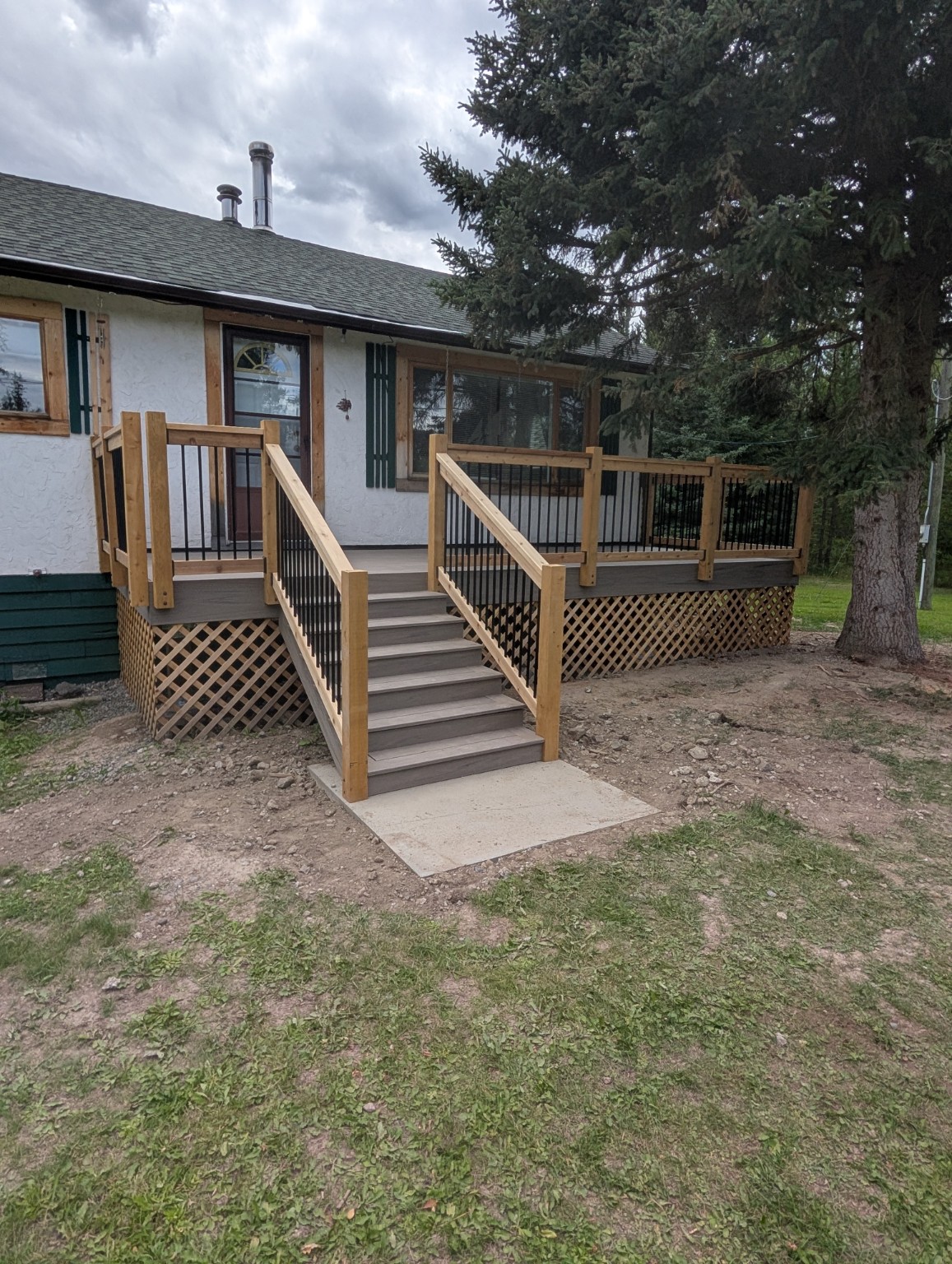 Front composite deck with stairs and black metal railing