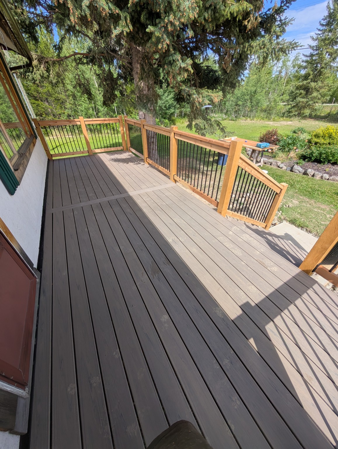 Second composite deck beside the home with wood and black metal railing